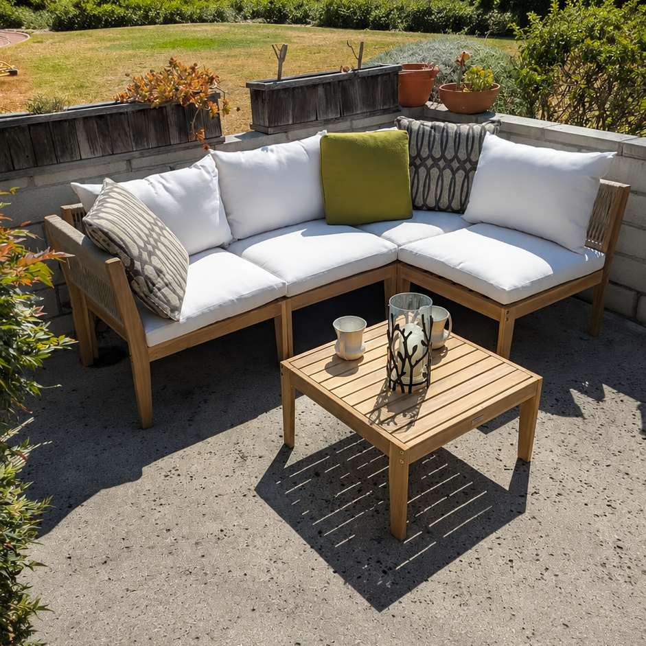 Outdoor wooden sectional sofa with white cushions and accent pillows on a patio, alongside a matching wooden coffee table, with a scenic garden and distant hills in the background.