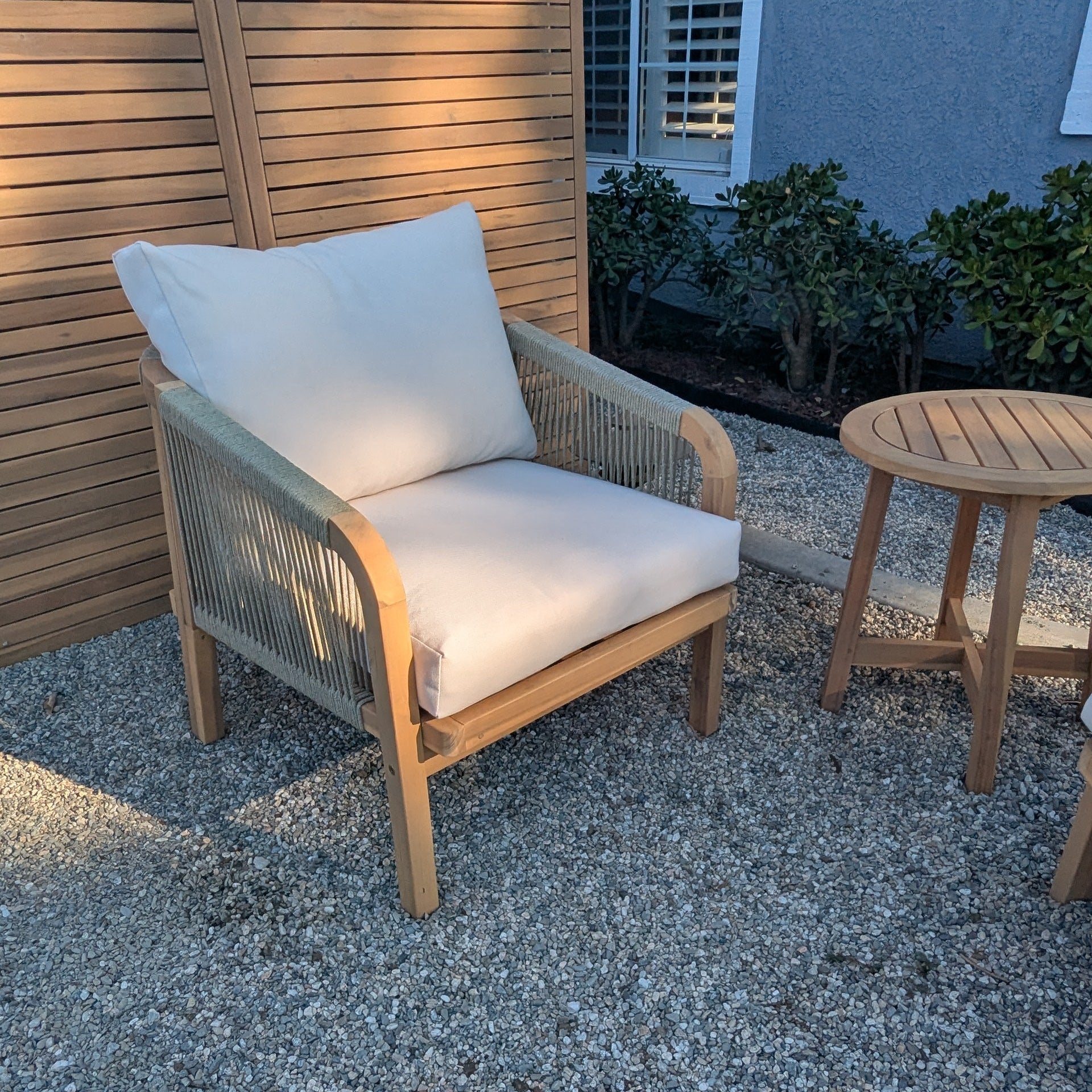 Kyndway Adele Lounge Chair with white cushions and a matching table on a gravel patio.